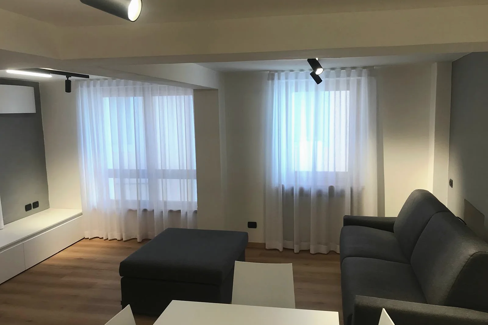 Sheer curtains across two adjacent windows, living room